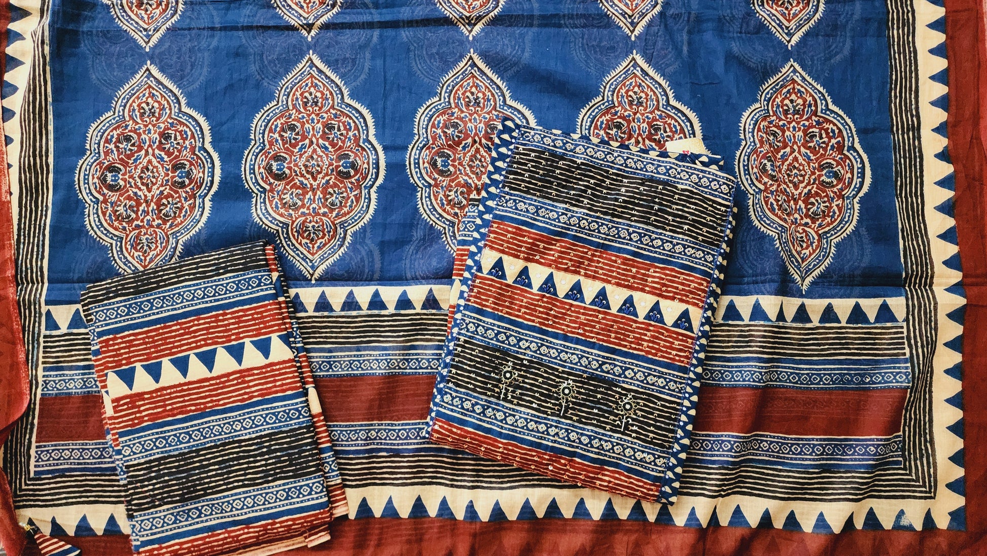Traditional patterned fabric with blue, red, and black colors on a red background